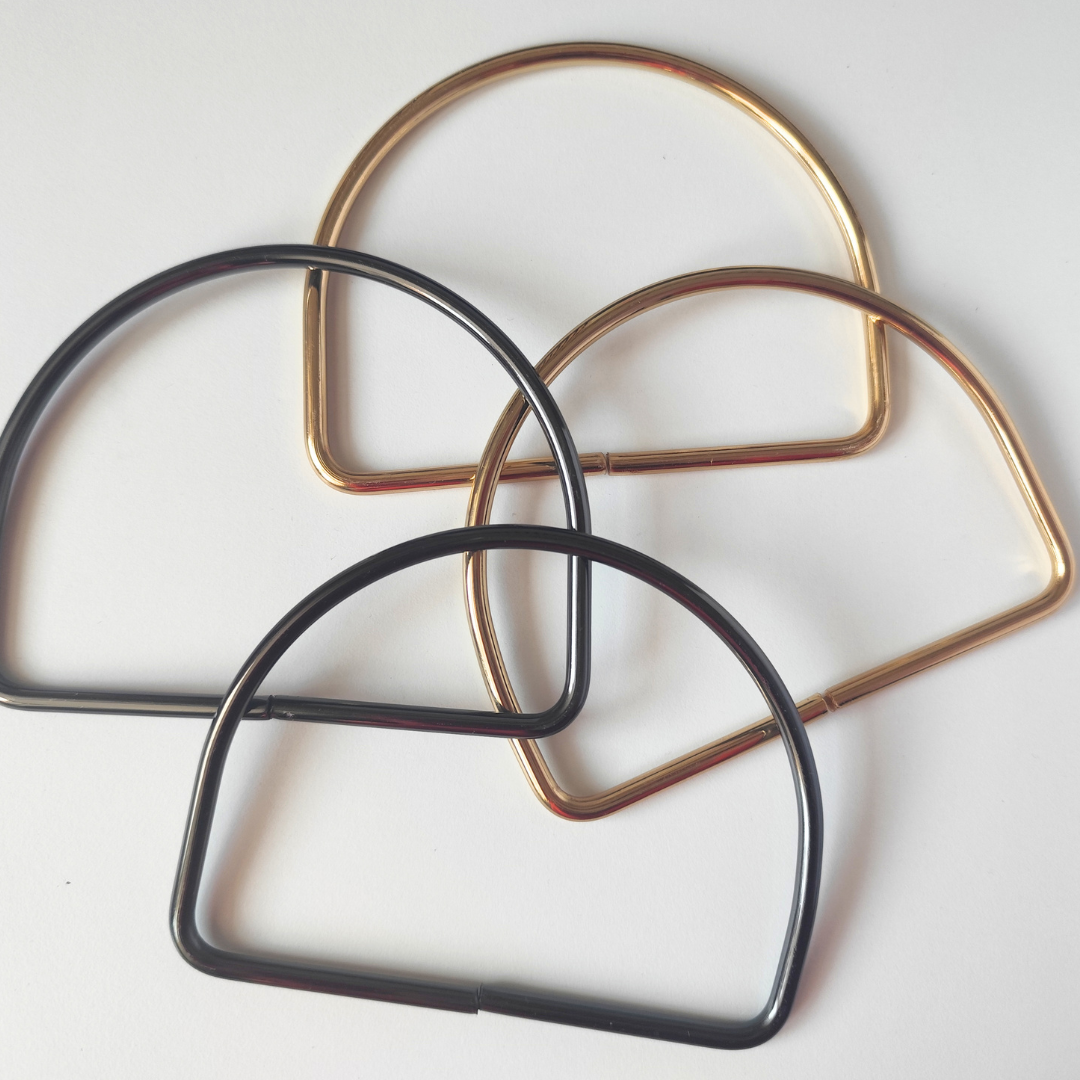 Three metal hair clips in black, gold, and bronze on a white background